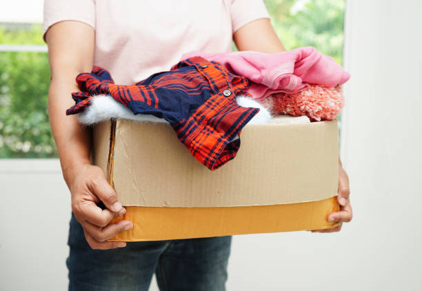 istock Clothes donations in cardboard box for volunteer. 1543093324