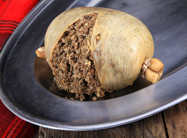 Haggis On A Silver Plater Scottish Haggis Cooked For A Burns Night Dinner Against A Royal Stuart Tartan haggis stock pictures, royalty-free photos & images