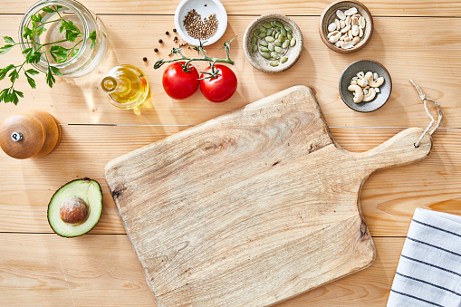 A beautiful light wooden natural kitchen table top background texture, with shades and shadows, background ideal for product placement, with a large copy space area