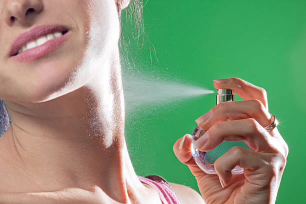 istock Beautiful young woman spraying parfume 154314227