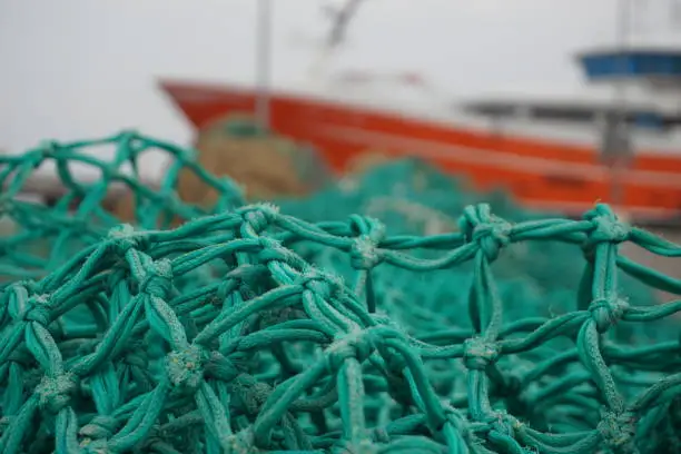 Photo of Fishing nets. Fishing nets with colorful buoys. Fishing gear and tackle. Industrial fishing. Fishing nets in the port on the floor.
