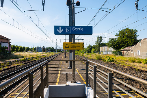 A train platform with railway tracks either side of it in Toulouse, France. There are no trains on the tracks.