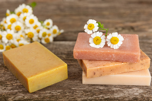 Natural homemade soap with chamomile flowers on a  background. Spa procedure. Beauty concept. Body skin care. Place for text. copy space.