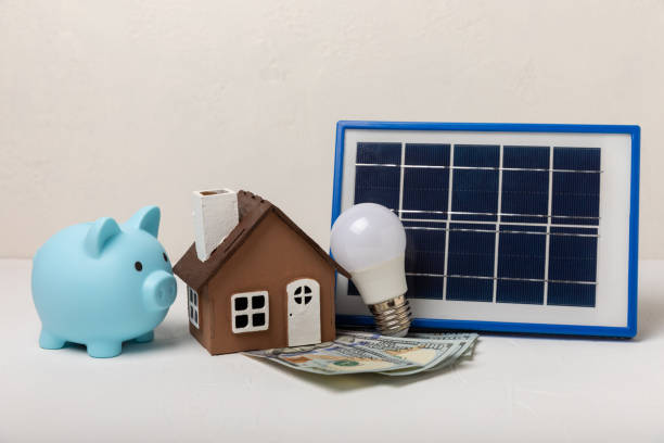 istock Flat lay composition with solar panel, led lamp and piggy bank on  background. The concept of saving money and clean energy. The concept of ecology and sustainable development. 1543180414