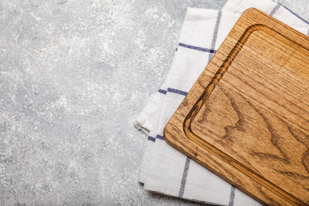 istock Cutting board on a textured  kitchen table. Menu food card or recipes background concept.MOCKUP. Design. Place for text, copy space. The concept of food and cooking. 1543181459