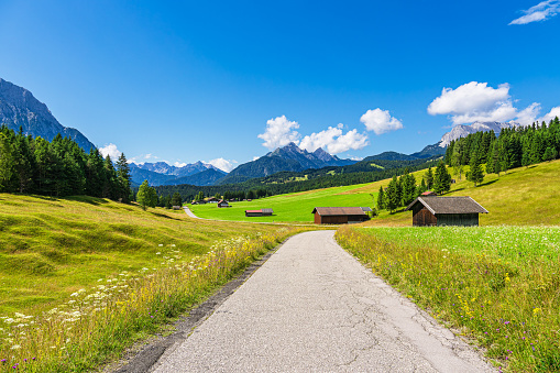 Hay huts and road in the Humpback Meadows between Mittenwald and Kruen, Germany.