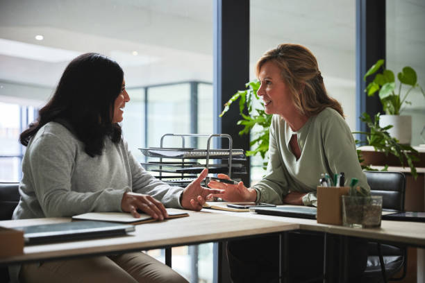 istock Creative workplace, conversation and business women in discussion for planning, ideas and strategy. Eco friendly office, corporate and female worker talking at desk for project, task and meeting 1543197738
