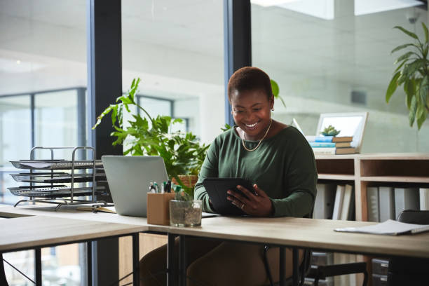 istock Web designer, tablet and black woman in office at table for business in creative startup. African professional, desk and technology with happy entrepreneur, developer and research email on internet. 1543197741