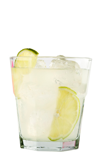 Gimlet drink with lime and ice in lowball glass isolated on white background