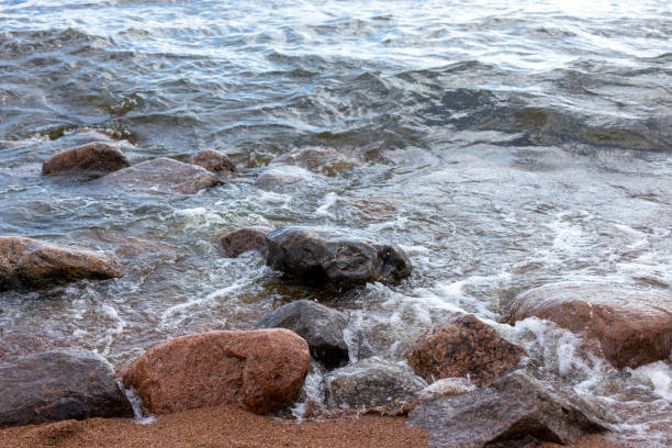 istock Sea shore water and wet coastal stones. 1543306470