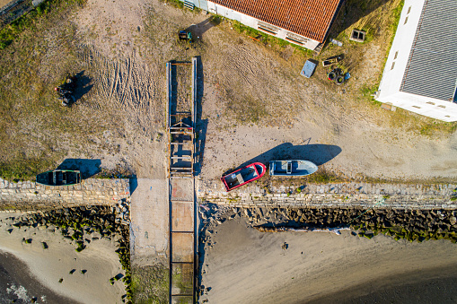 zenithal aerial view of a small fishing boat stranded for repairs