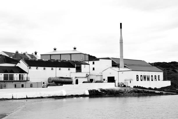 Bowmore Whisky Distillery on the isle of Islay, Scotland Bowmore distillery produces Scotch whisky on the Isle of Islay, an island of the Inner Hebrides. The distillery, which lies on the South Eastern shore of Loch Indaal, is one of the oldest in Scotland. bowmore whisky stock pictures, royalty-free photos & images