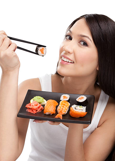 istock Smiling woman holding sushi roll 154341865