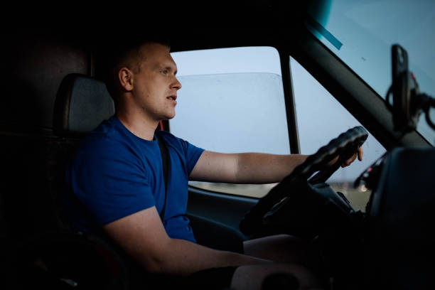 istock male trucker rides on a sunny day for a trip. Young van driver 1543419062