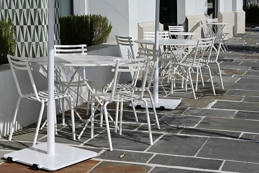 Chairs and tables outside restaurant on the walkway.