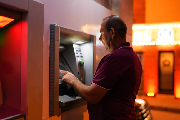 istock senior man makes deposits at atm in the evening 1543420119