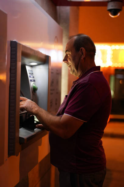 istock senior man makes deposits at atm in the evening 1543420562