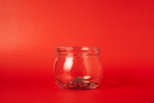 Coins in glass jar on abstract background, Financial business investment, Growing money, Global financial crisis, People saving money, Money saving concept. High quality photo