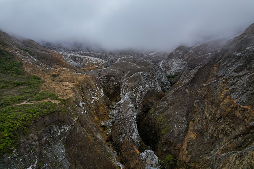 Beautiful nature view of the the Poas Volcano Canon, mountains and trial hick to the tourquoise waters with explorers