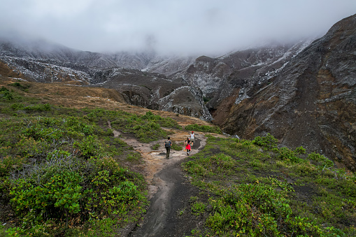 Beautiful nature view of the the Poas Volcano Canon, mountains and trial hick to the tourquoise waters with explorers