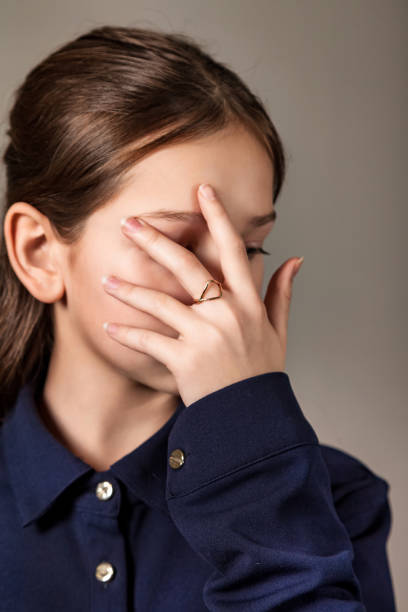 Close-up portrait of pretty teen girl covered face with hand posing in studio, bored look. Lovely jewish teenager lady poses with deep emotion. Gen Z. Fashion image style concept. Copy ad text space retrato en primer plano de una linda adolescente cubierta con la cara cubierta con la mano posando en el estudio, mirada aburrida. encantadora adolescente judía posa con profunda emoción. gen z. concepto de estilo de imagen de moda. copiar el espacio de