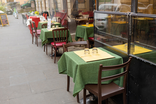 Shot of an empty restaurant filled with tables and chairs inside during the day