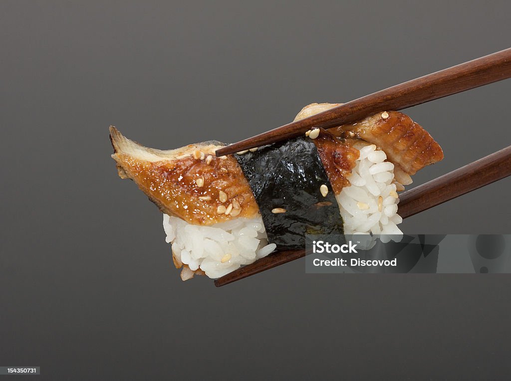 Sushi with chopsticks Sushi with chopsticks isolated over gray background Appetizer Stock Photo