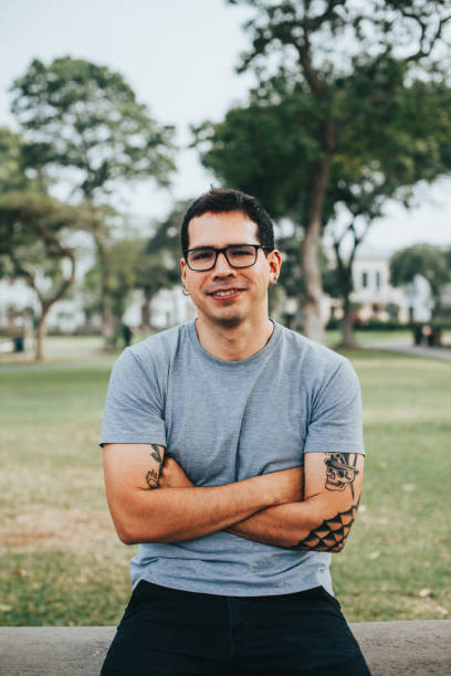 istock Young man with glasses smiling in a park. 1543519251