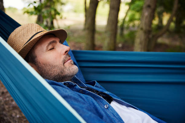 istock Man taking a nap sleeping in hammock in forest during summer vacation 1543521377