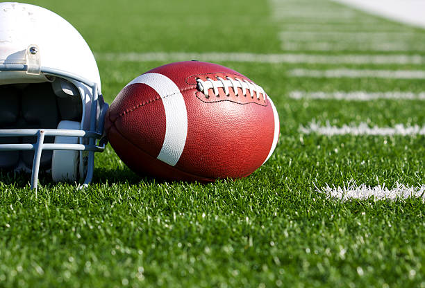 Football and Helmet on the Field stock photo
