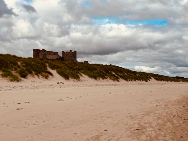 bamburgh beach with bamburgh castle in the background - bamburgh bamburgh castle sand dune history imagens e fotografias de stock