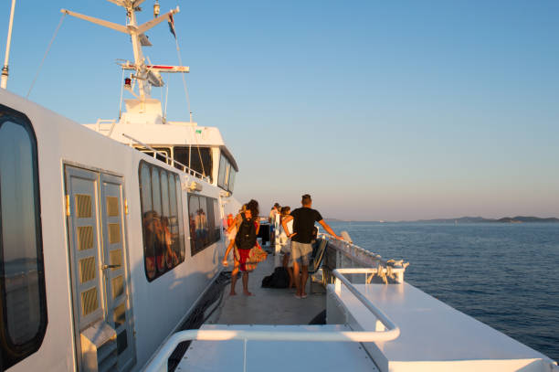Vodice, Croatia - August 25, 2021: Young people walking away from moored Jadrolinija ship on the pier