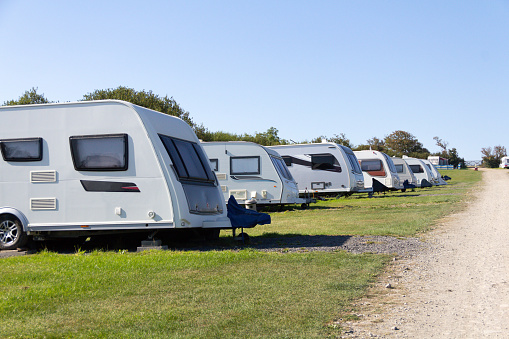 Row of caravans parked on Caravan Park in rural Wales ready for tourists to use as base for their vacations holidays on a sunny summers day.