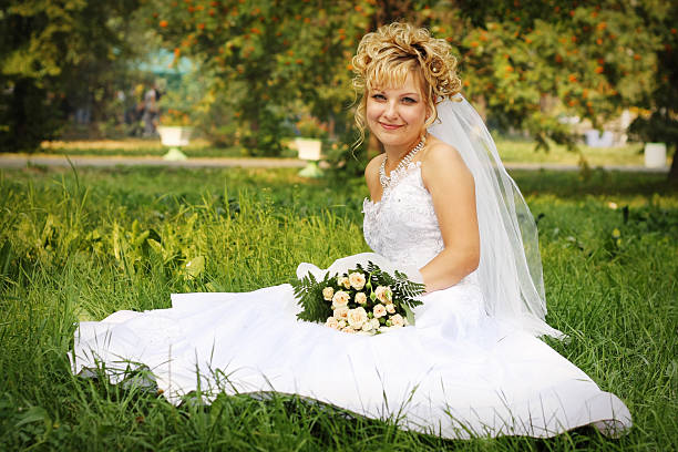 Happy bride at a park in grass stock photo