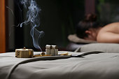 Moxibustion treatment - traditional Chinese medicine tools for acupuncture points heating therapy. Moxibustion copper burner box on woman's back for warm massage. Chinese herbal medicine.