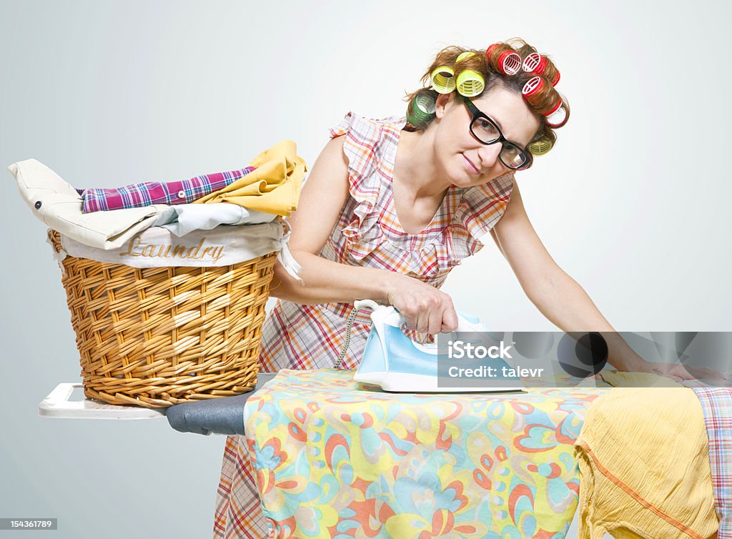 Housewife Housewife ironing full laundry basket with clothes Adult Stock Photo