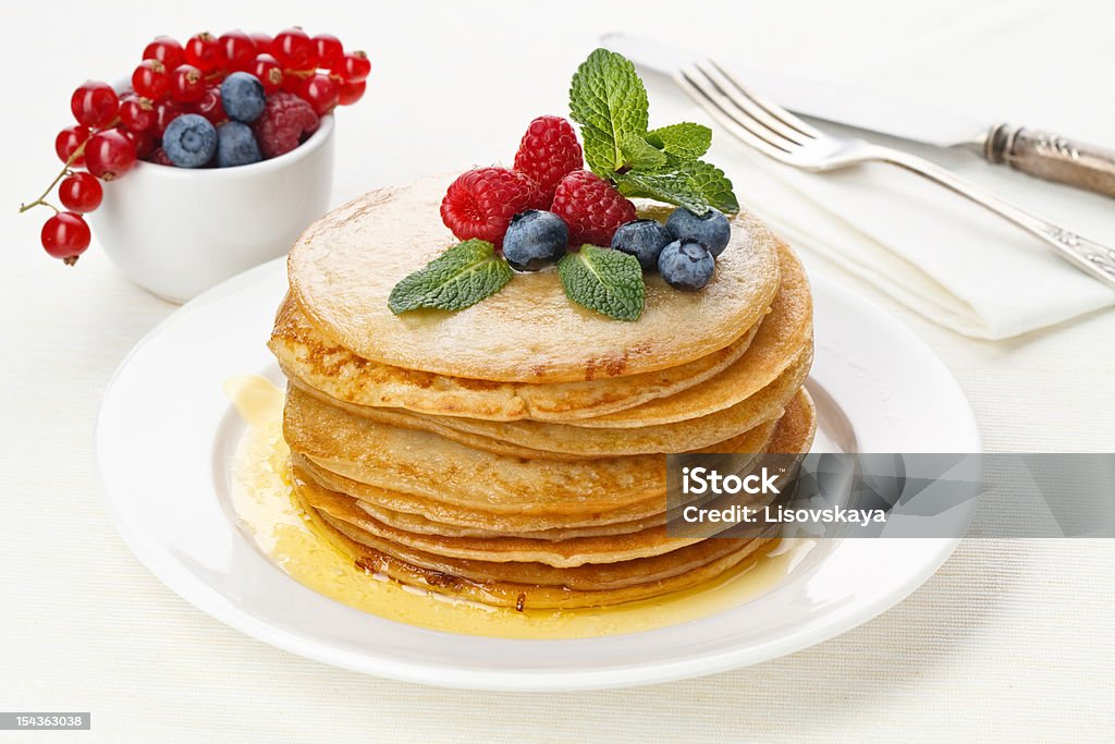 Pile of pancakes with raspberries and bilberries Pile of delicious handmade pancakes topped with raspberries and bilberries Bilberry - Fruit Stock Photo