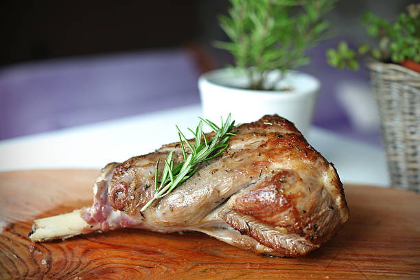 Roasted leg of lamb with rosemary on the cutting board stock photo