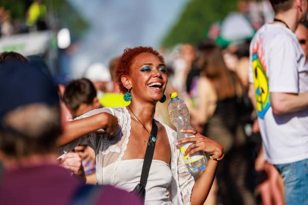 Three young women are having fun taking a selfie at a music festival illuminated by colorful lights