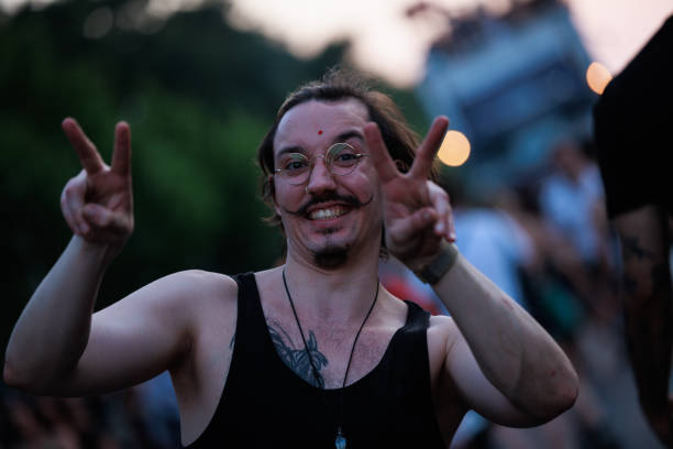 Santa Fe, NM: A Latino man with locs and facial hair on the Santa Fe Plaza looks at the camera. Close-up shot.