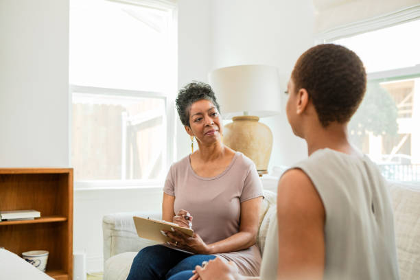 istock Mature female therapist listens to unrecognizable female client 1543680491
