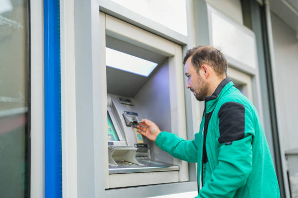 istock man withdrawing money from atm with card 1543697547