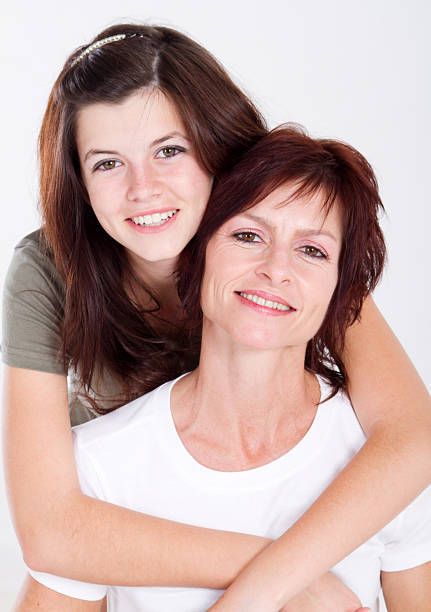 Hispanic mature woman posing with her young daughter