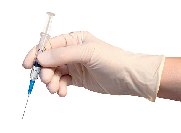Syringe in gloved hand stock photo
