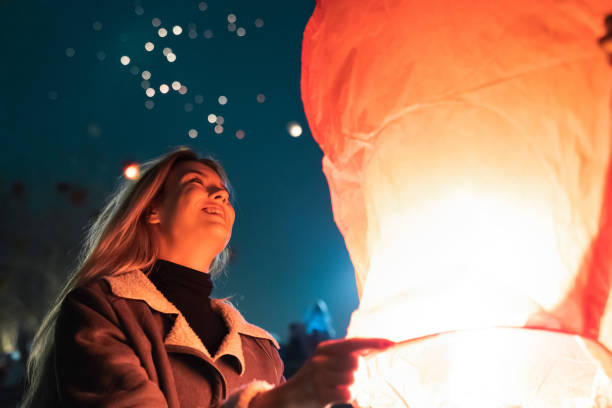 istock Beautiful woman looking at the sky with lanterns 1543720967
