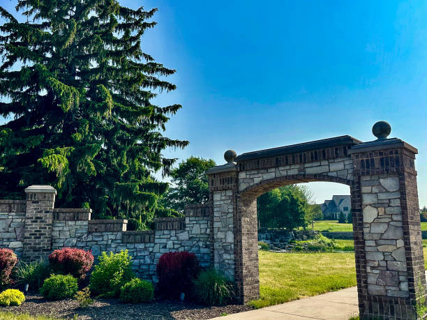 istock Stone wall fence with majestic archway over sidewalk 1543773515