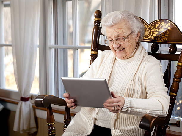 großmutter mit tablet-computer - great grandmother stock-fotos und bilder