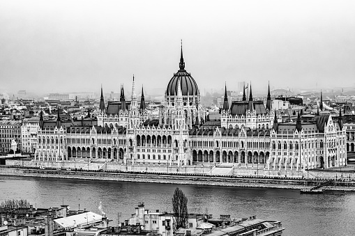 Palace of Westminster where Houses of Parliament meet along the Thames River, London, England.  Boats moored along the Albert Embankment in foreground. Photo taken August 7, 1967.