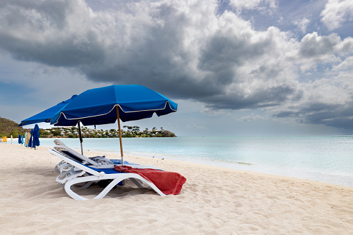 Lounge chairs and umbrellas on a Beautiful tropical beach, Valley Church Beach, Jolly Harbour, Antigua and Barbuda