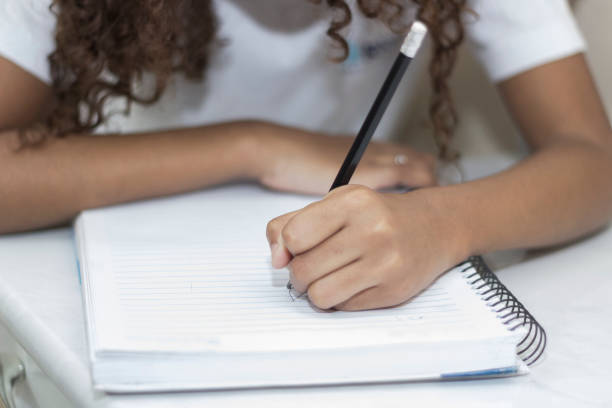 istock Hands of a child studying Doing Her Homework 1543888166
